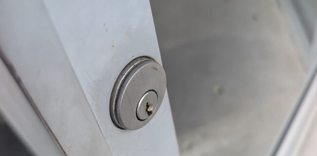 Commercial locksmith deadbolt on a metal storefront door in Waco