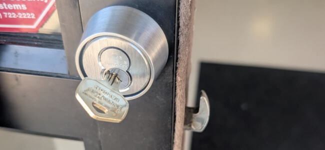 Lock cylinder and key on a storefront door, fitted by a Texas locksmith