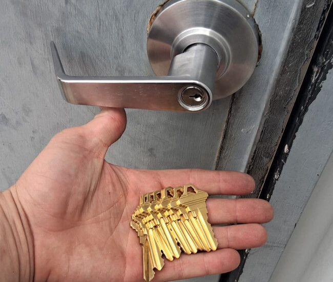 Locksmith holding freshly cut brass keys in Temple