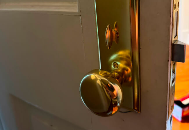 Residential locksmith servicing a brass mortise lock in College Station