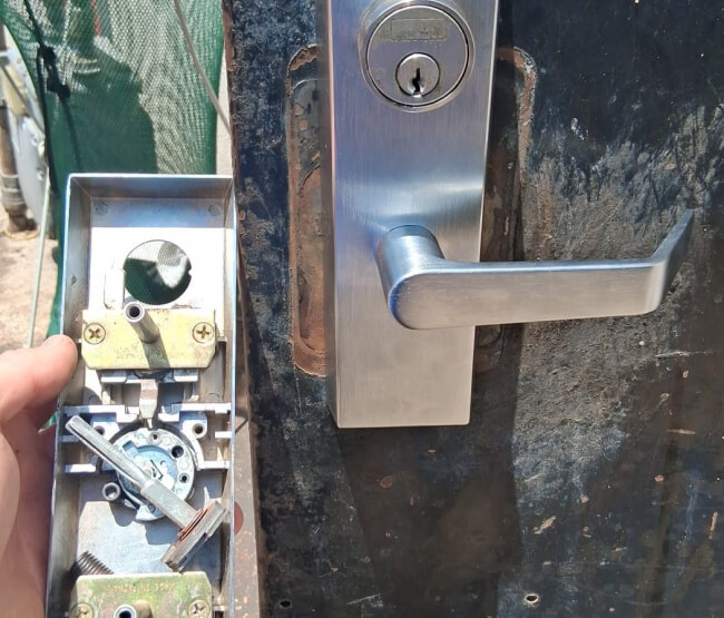 Texas locksmith servicing a door lock and lever handle on site